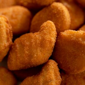 Close-up of crispy, golden-brown chicken nuggets arranged together, highlighting texture.
