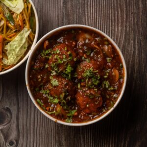 Indulge in a flavorful Indo-Chinese combo of vegetable noodles and spicy Manchurian for a delightful meal.