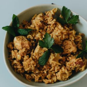 Savor a bowl of flavorful chicken fried rice garnished with fresh herbs.