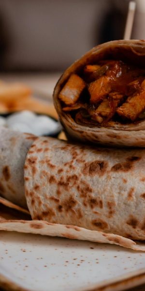Tasty chicken wraps served with crispy fries and sauce, perfect for a casual meal.